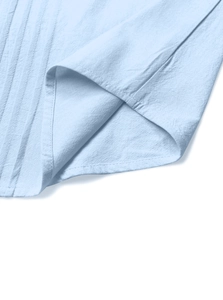 Détail de l'ourlet d'une chemise en coton et lin bleu clair avec couture à double aiguille
