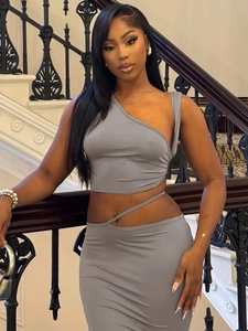 Detail of grey asymmetric crop top and low waist bodycon skirt on a chic model