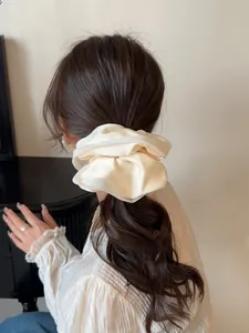 Rear view of elegant cream satin scrunchie styling a low bun hair look