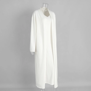 Detail of white knit cardigan and matching long dress set showing soft fabric texture
