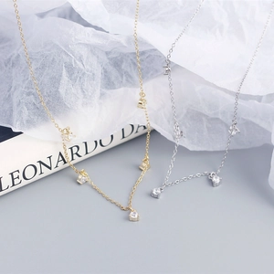 Close-up of gold and silver S925 necklaces with sparkling zircon pendant details
