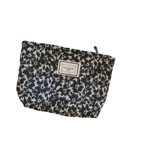 Floral fabric makeup bag with TIME TO PARTY patch and black zipper in black and white