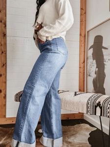Detail van retro jeans met brede pijpen voorzien van omgeslagen zomen en rafelranden