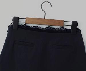 Détail de la dentelle noire et de la fermeture éclair invisible sur la jupe en tissu