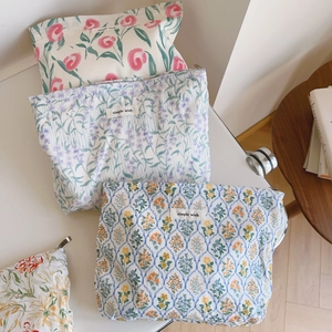 Gros plan de trousses à maquillage en coton aux quatre motifs floraux et étiquettes