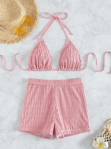 Flat lay of pink pointelle bikini set with high-waisted shorts on marble background