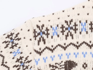 Détail macro du motif nordique et de la texture sur un pull d'hiver en maille beige