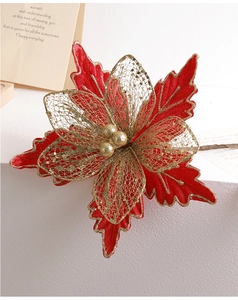 Close-up of velvet poinsettia Christmas flower with gold glitter and mesh petals