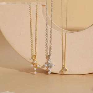 Detailed view of cross pendants with pearls and rhinestones on gold and silver chains