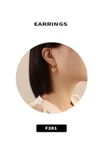 Detail view of model wearing gold heart pendant earrings with mirror-like metallic finish