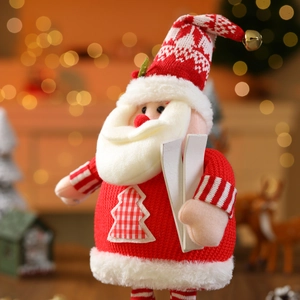 Detail of Christmas Santa gnome with knitted sweater, red plaid patch, and wooden skis