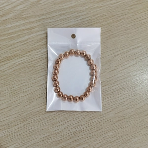 Rose gold beaded bracelet on wooden background showing smooth metallic finish and elastic band