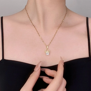 Détail du collier doré avec lettrage LOVE et pendentif cœur en zircon sur le mannequin