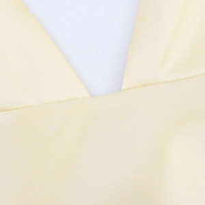 Detail of elegant beige satin dress showing smooth fabric texture and V-neckline design