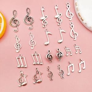 Detailed overhead view of 20 silver musical note charms for DIY jewelry and necklaces