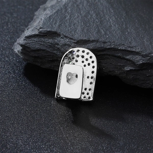 Macro shot of silver hip hop grillz with heart design and zircon stones on rock