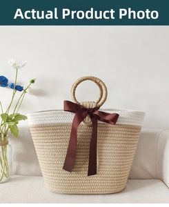 Detail of hand-woven cotton rope tote bag with a large brown satin bow on beige sofa