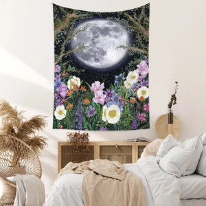 Detail of bohemian tapestry featuring moon, floral forest patterns and soft sunlight