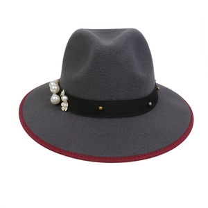Detail of dark grey wool felt fedora featuring burgundy trim and pearl floral accents