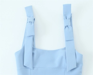 Detail of light blue top with bow-knot shoulder straps and elegant square neckline