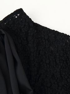 Macro detail of black lace and satin fabric textures on a women's bodysuit