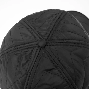 Macro shot of black baseball cap top with star quilted pattern and fabric texture