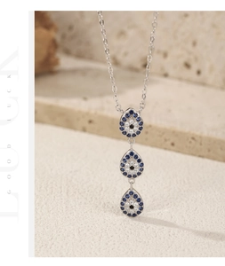 Close-up of three-tier Evil Eye teardrop pendants on a sterling silver Y-shaped chain