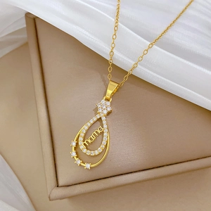 Détail du pendentif goutte d'or avec inscription mama et pavé de cristaux brillants