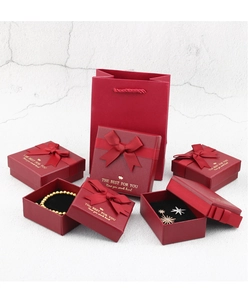 Macro shot of red jewelry gift boxes with gold text and elegant bow ribbons