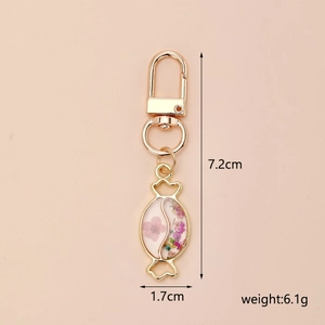 Detail showing dimensions of candy-shaped dried flower keychain with gold-tone alloy