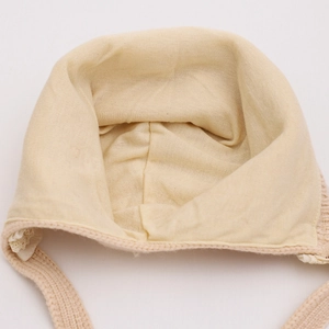 Detailed close-up of soft knitted baby bonnet interior with smooth stitching and ear flaps
