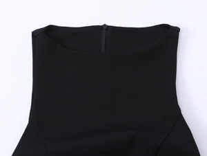 Close-up detail of the black sleeveless dress neckline with a discreet back zipper closure