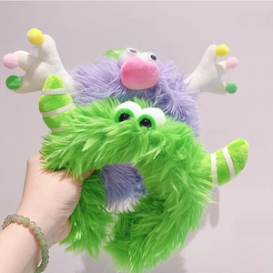Detail of plush monster headbands in green and purple colors with cute cartoon features