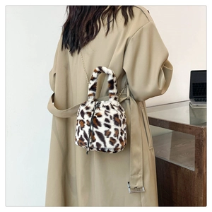 Fashionable leopard print plush bucket bag with chain strap shown on model's shoulder