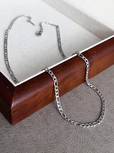 Detailed shot of a silver Figaro chain necklace 41+5cm on a wooden display box