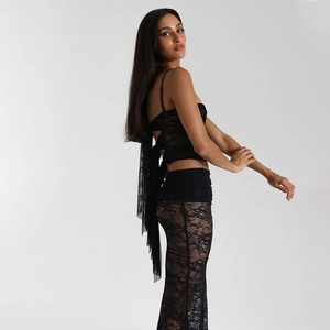 Detail of black lace two-piece set featuring back bow design and sheer maxi skirt