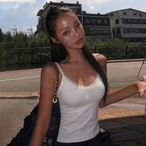 Outdoor shot showing details of a white lace-trimmed camisole with a black quilted chain bag