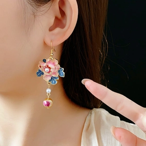 Detail view of vintage flower earrings with pink enamel petal and pearl drop on model