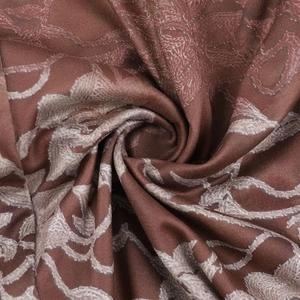 Macro view of silky brown vintage vine pattern fabric with smooth draped texture