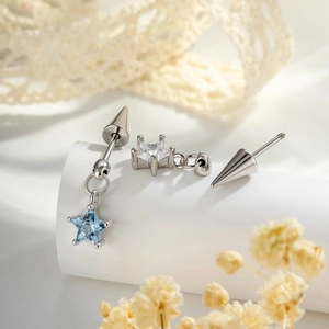 Three-piece silver star and cone earring set with blue crystals on a display