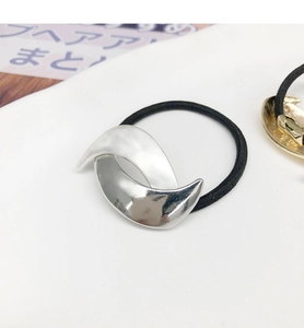 Close-up of a silver crescent metal hair tie with a sleek polished finish on white background