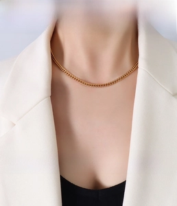 Detailed view of 3.7mm 18k gold-plated stainless steel curb chain on a model's neck