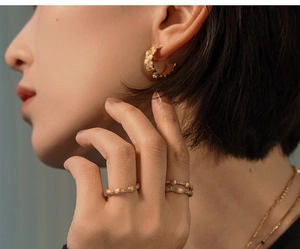 Close-up of golden frosted S925 silver ring and earrings with zircon inlay on model