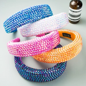 Close-up of five handmade padded headbands with vibrant rhinestones in various colors