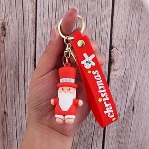 Close-up of Santa Claus PVC keychain with red silicone strap and gingerbread man charm