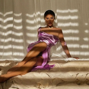 Détail de robe en satin violet à col bénitier avec fente haute et taille cintrée dos nu