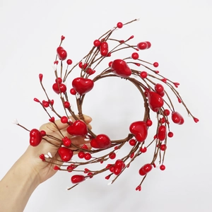 Detail of a 30cm heart wreath featuring red berries and white buds on a twig base