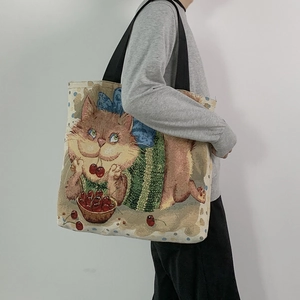 Detail of canvas tote bag showing the cartoon cat printing and sturdy black handles