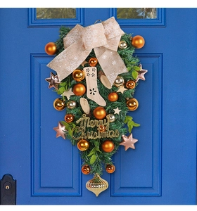 Detail of Christmas swag with baubles and Merry Christmas sign on a blue door