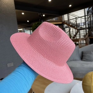 Close-up of pink woven straw hat with fine texture and flat top for sun protection